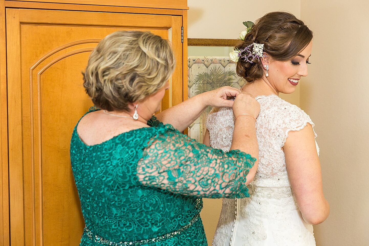 Photo of mother buttoning up the bride in her wedding dress at the Hilton Boca Raton Hotel | Photo by Boca Wedding Photographer
