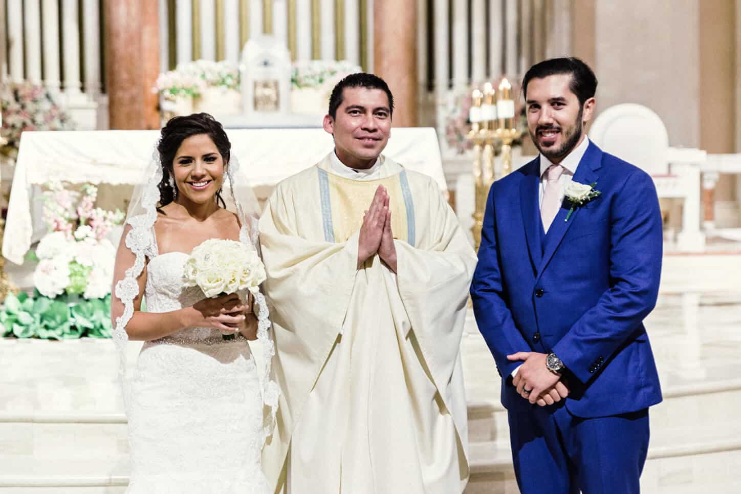 Wedding Party Photo of Bride and Groom With Their Priest