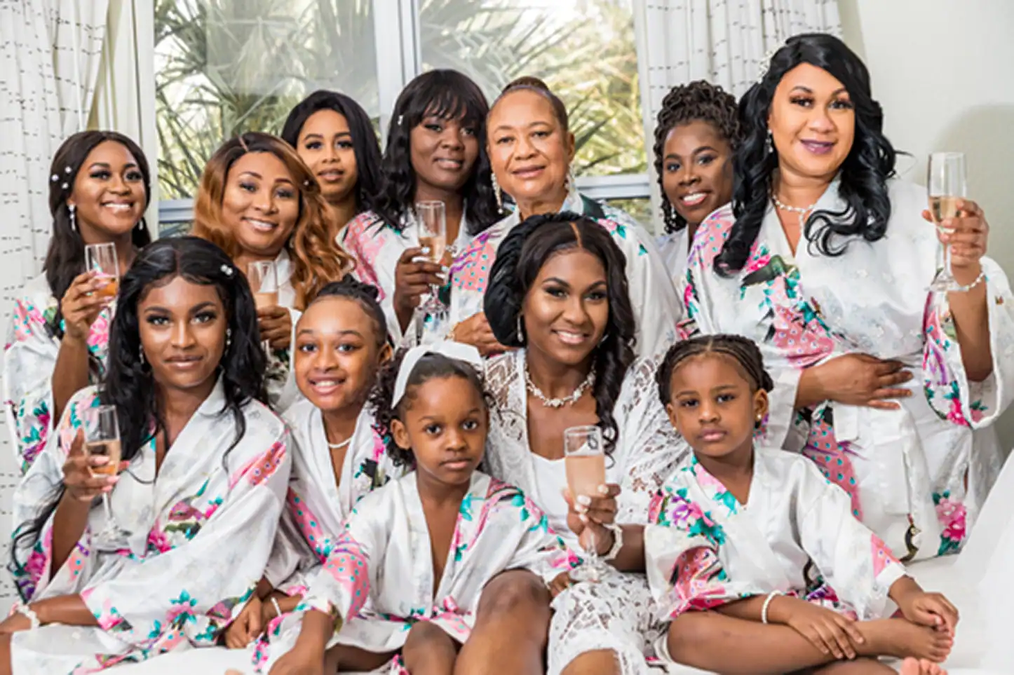 The bridal party and bride smiling during a champagne toast at Residence Inn Fort Lauderdale before the Bamboo Gallery wedding.