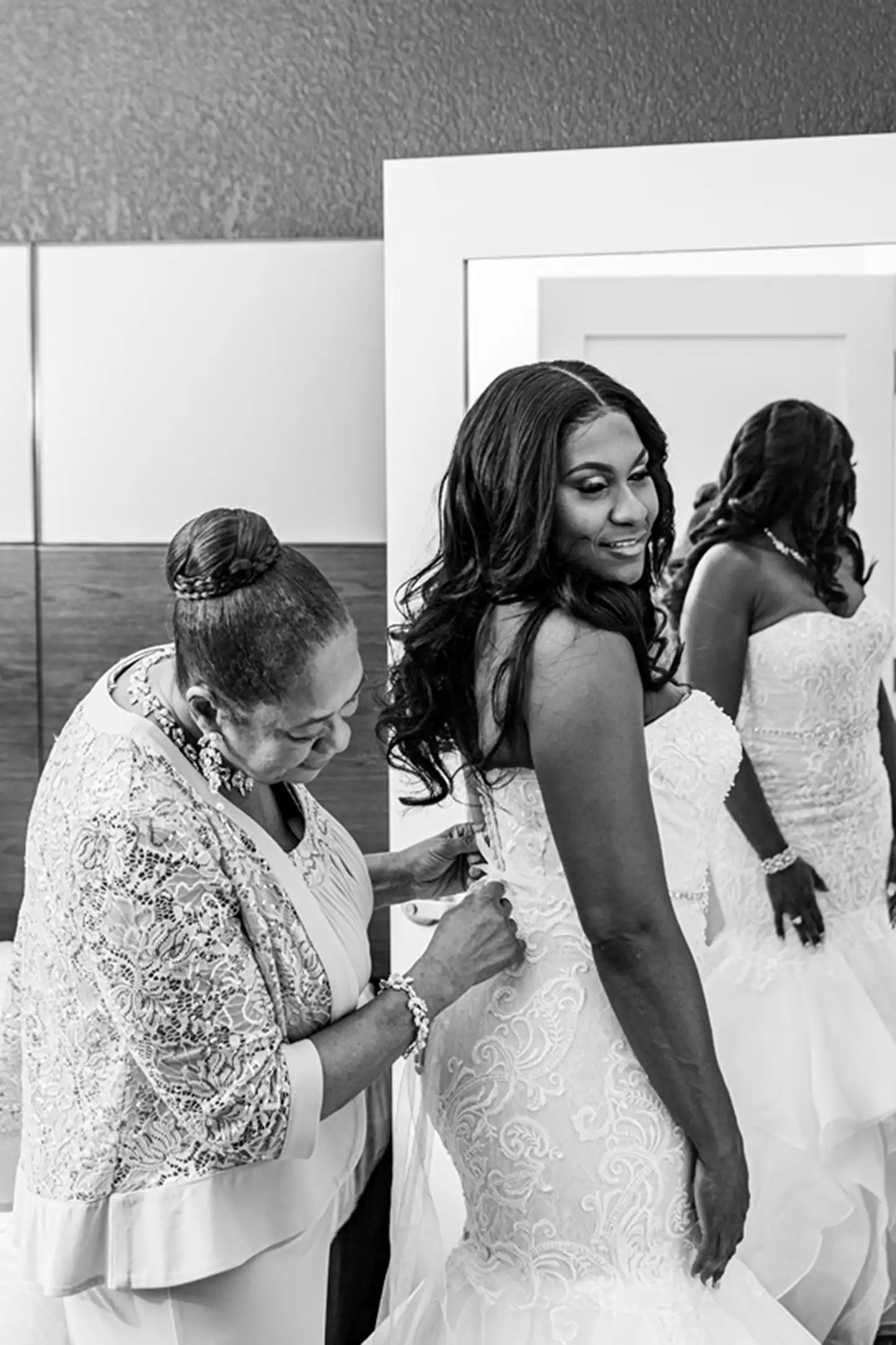 Black and white image of the bride’s mother putting the finishing touches on her dress before the Bamboo Gallery wedding in Fort Lauderdale.