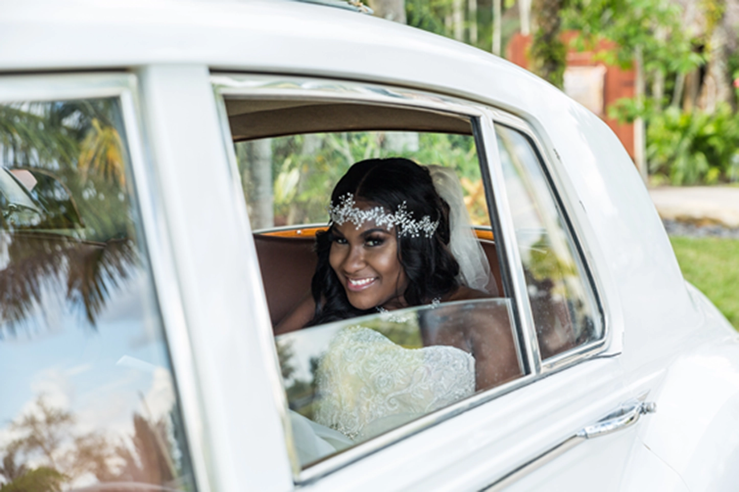 Bride posing beside a vintage Rolls-Royce at the Bamboo Gallery wedding venue in Davie, Florida.