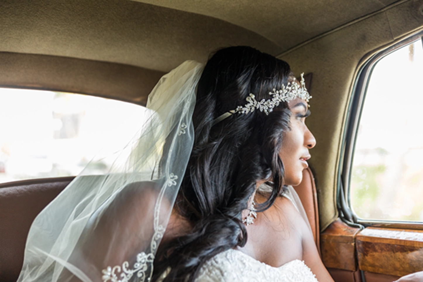Bride posing beside a vintage Rolls-Royce at the Bamboo Gallery wedding venue in Davie, Florida.