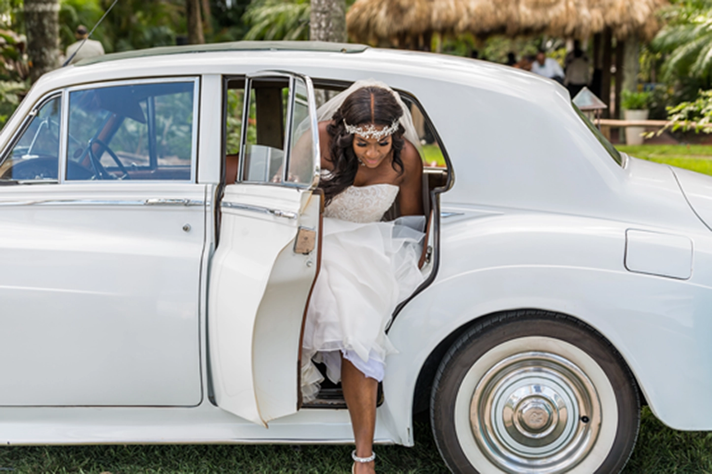 Bride posing beside a vintage Rolls-Royce at the Bamboo Gallery wedding venue in Davie, Florida.