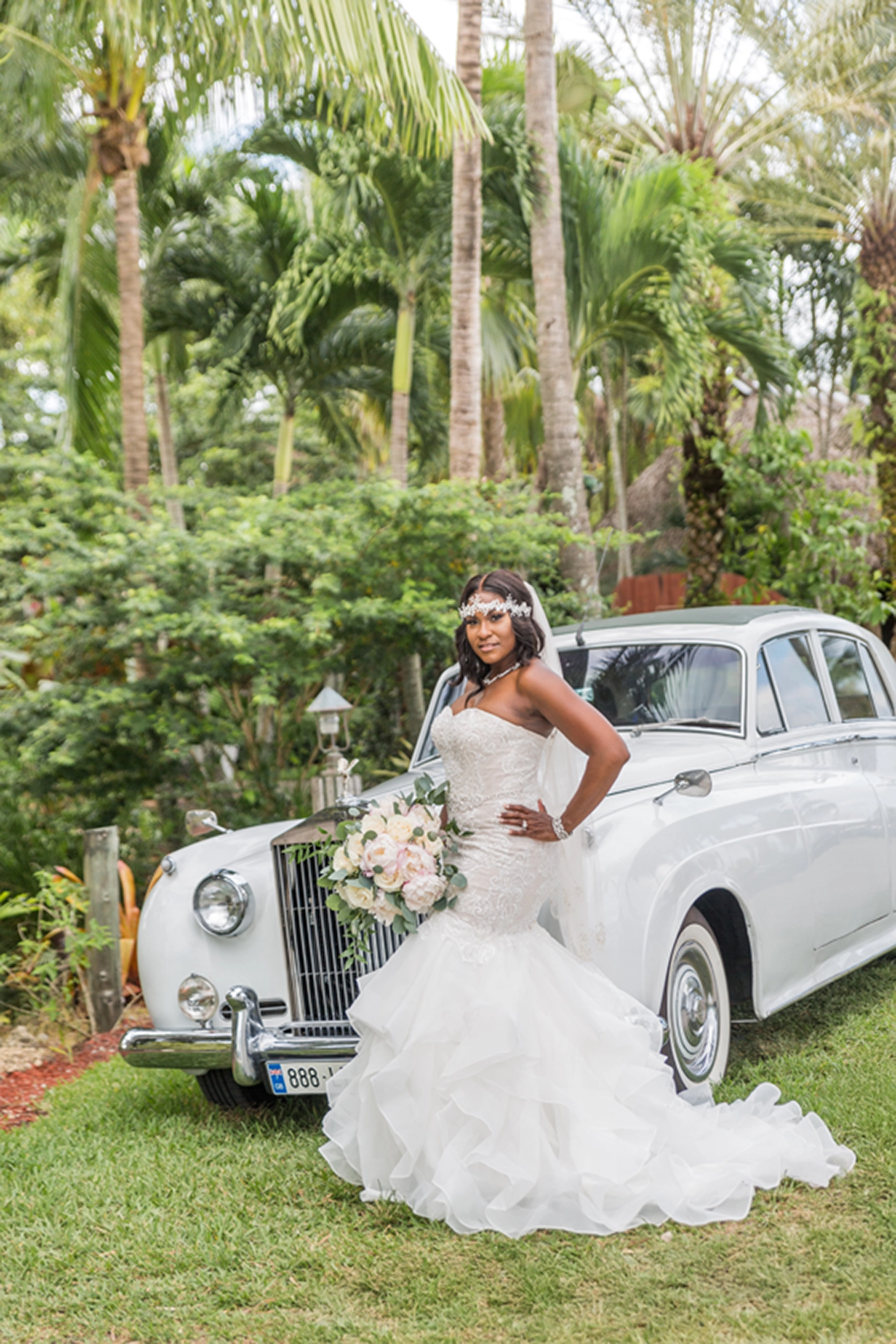 Bride posing beside a vintage Rolls-Royce at the Bamboo Gallery wedding venue in Davie, Florida.