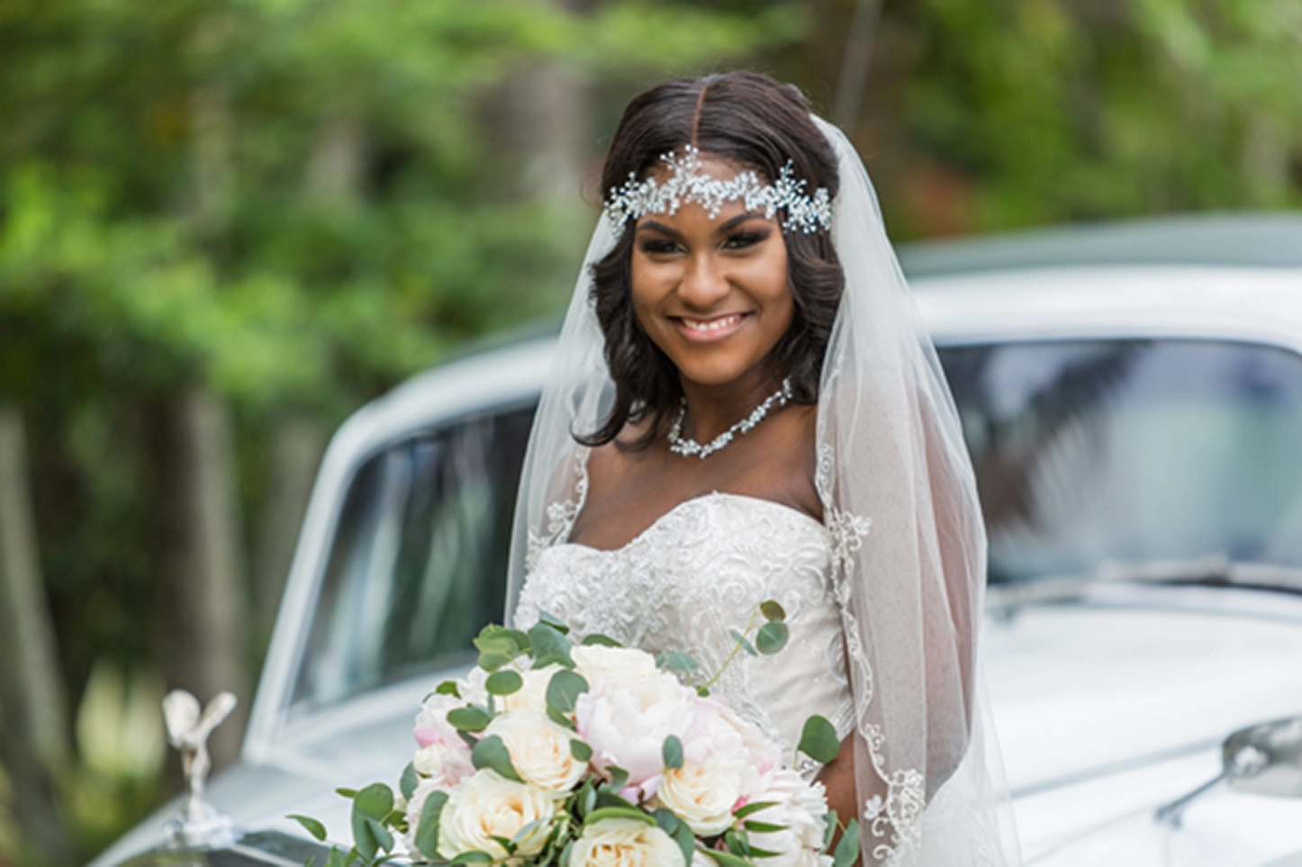 Bride posing beside a vintage Rolls-Royce at the Bamboo Gallery wedding venue in Davie, Florida.